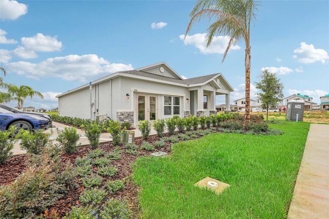 view of home's exterior featuring a lawn and french doors