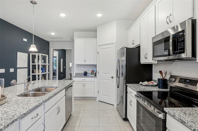 kitchen with pendant lighting, sink, light tile patterned floors, appliances with stainless steel finishes, and white cabinetry