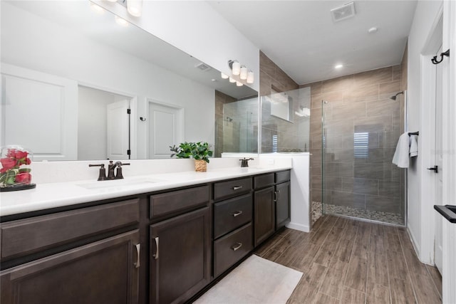 bathroom featuring a shower with door, vanity, and hardwood / wood-style flooring