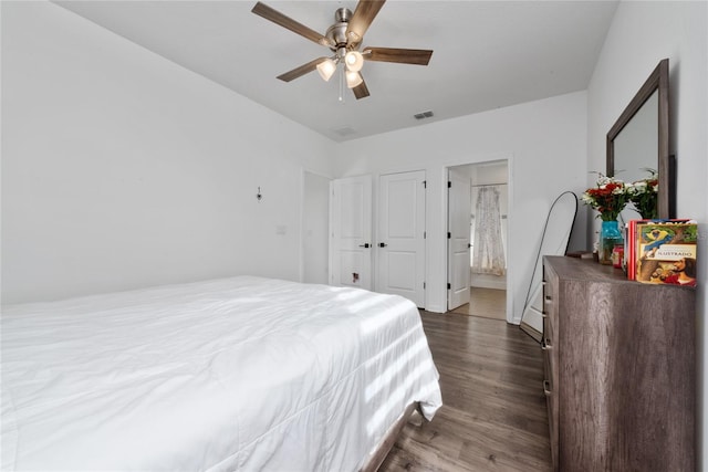 bedroom featuring ceiling fan, dark hardwood / wood-style flooring, and connected bathroom