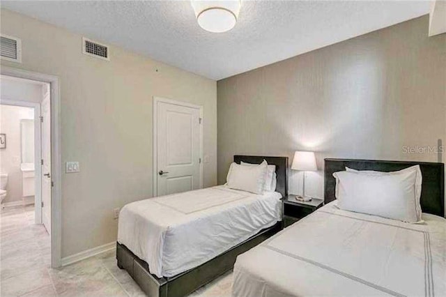 bedroom featuring a textured ceiling and connected bathroom