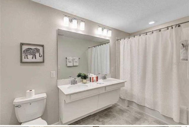 bathroom featuring tile patterned floors, vanity, shower / bathtub combination with curtain, and a textured ceiling