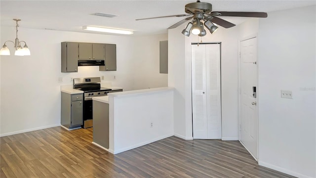 kitchen with stainless steel range, ceiling fan with notable chandelier, decorative light fixtures, and dark hardwood / wood-style floors