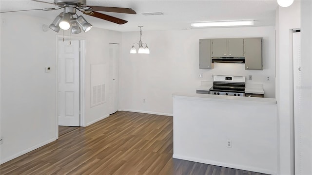 kitchen featuring stainless steel range, hanging light fixtures, dark hardwood / wood-style flooring, exhaust hood, and ceiling fan with notable chandelier