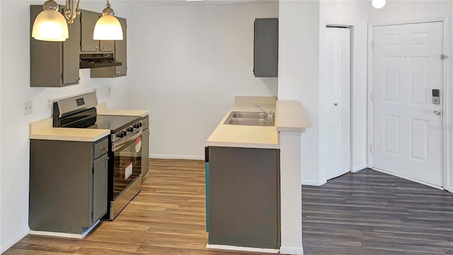 kitchen featuring electric range, sink, dark hardwood / wood-style flooring, a notable chandelier, and decorative light fixtures