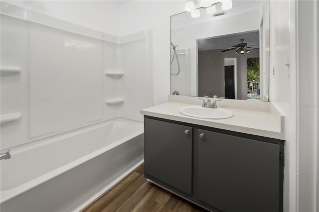 bathroom with hardwood / wood-style floors, vanity, shower / washtub combination, and ceiling fan