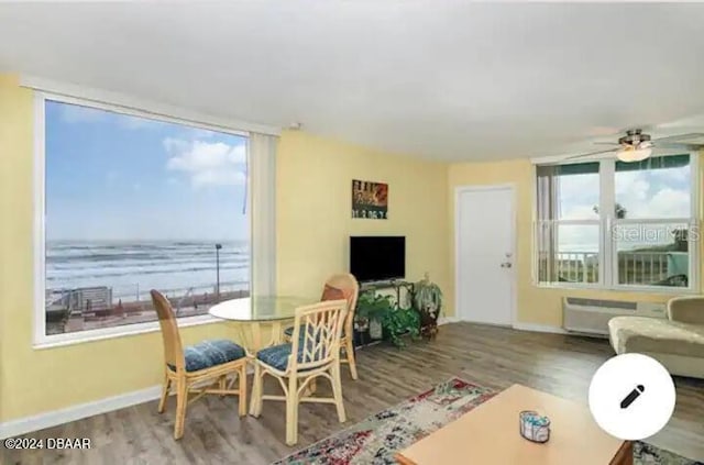 dining space with baseboards, wood finished floors, a ceiling fan, and radiator