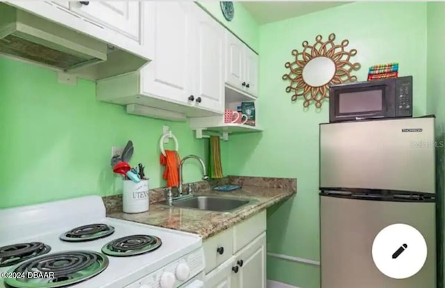 kitchen featuring white cabinets, freestanding refrigerator, white electric range, black microwave, and a sink