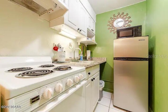 kitchen with black microwave, extractor fan, a sink, freestanding refrigerator, and white electric range oven