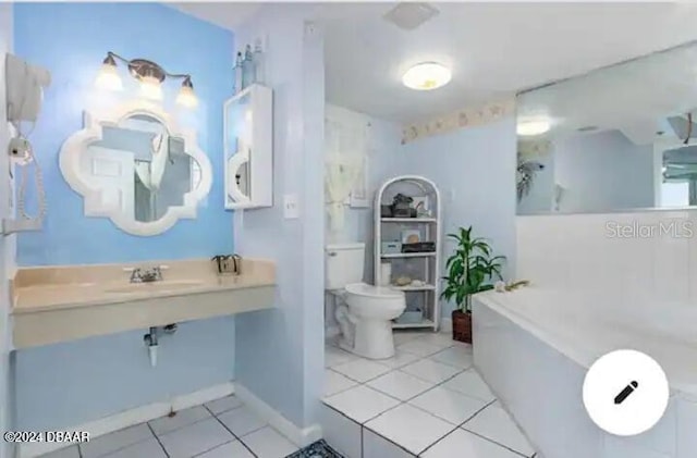 full bath with a garden tub, a sink, toilet, and tile patterned floors