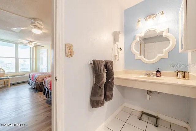 bathroom featuring a sink, tile patterned floors, a ceiling fan, and baseboards