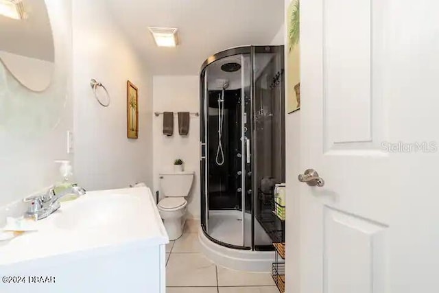 full bathroom with a stall shower, vanity, toilet, and tile patterned floors