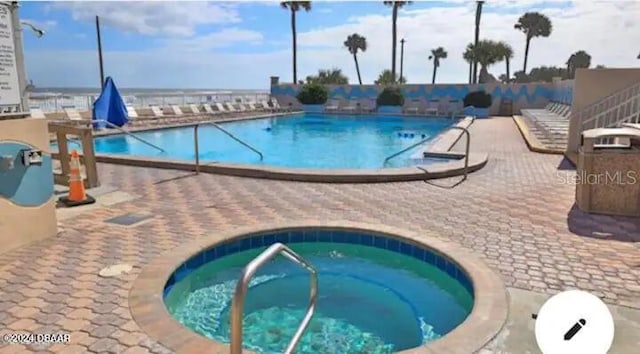 community pool featuring a patio area and a community hot tub