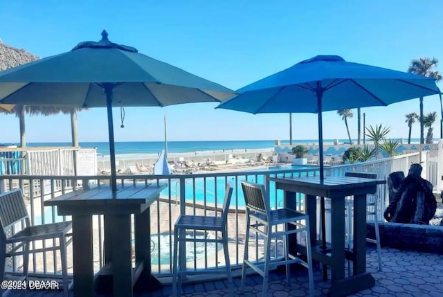 exterior space featuring a water view, a community pool, and a beach view