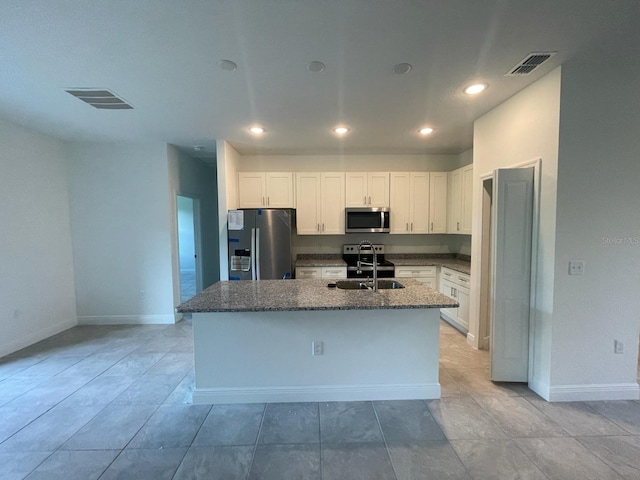 kitchen featuring an island with sink, stainless steel appliances, white cabinetry, and sink