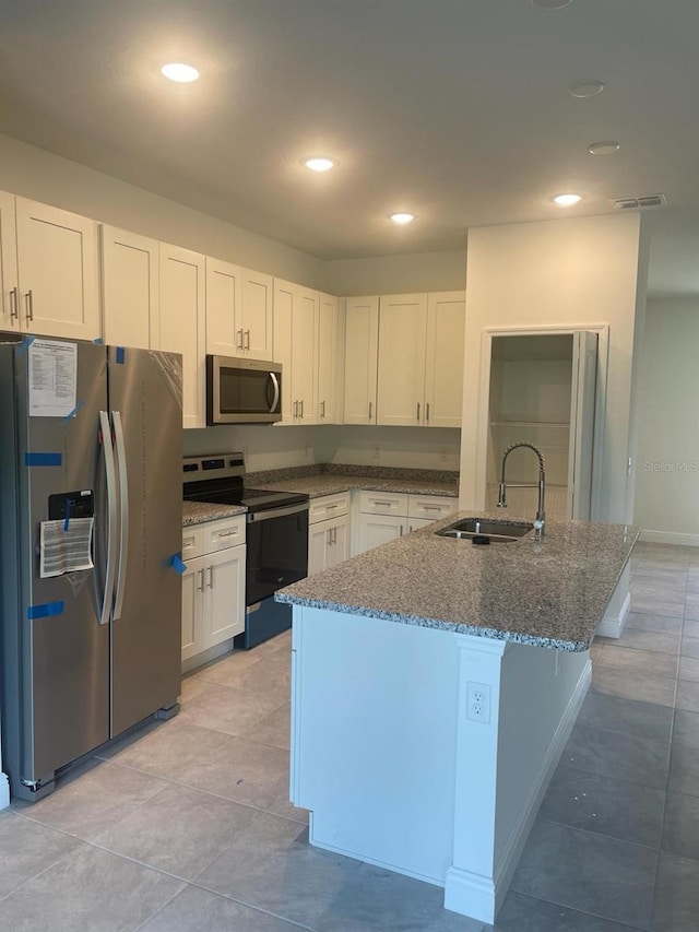 kitchen featuring dark stone countertops, white cabinetry, sink, and appliances with stainless steel finishes