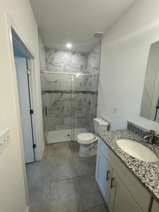 bathroom featuring vanity, toilet, and a shower with door