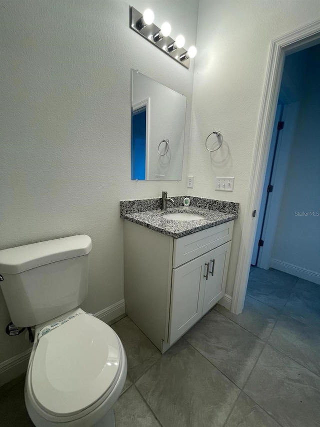 bathroom featuring tile patterned floors, vanity, and toilet