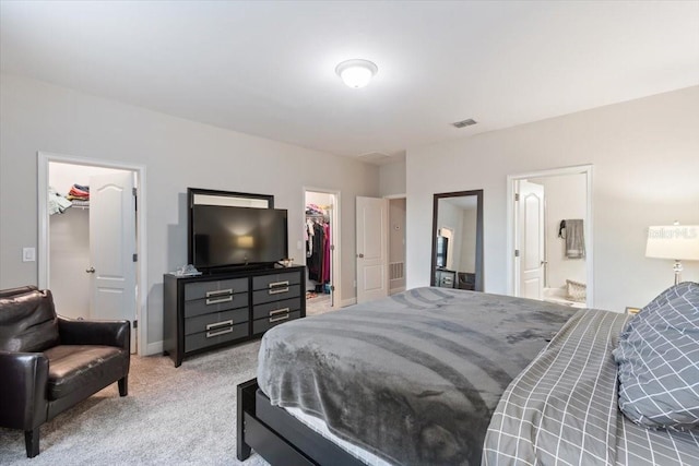 carpeted bedroom featuring a spacious closet, connected bathroom, and a closet