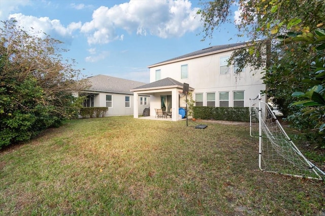 rear view of property featuring a patio area and a yard