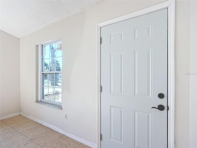 interior space with a textured ceiling and light tile patterned flooring