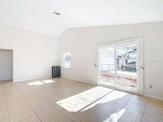 unfurnished room featuring light tile patterned flooring and lofted ceiling