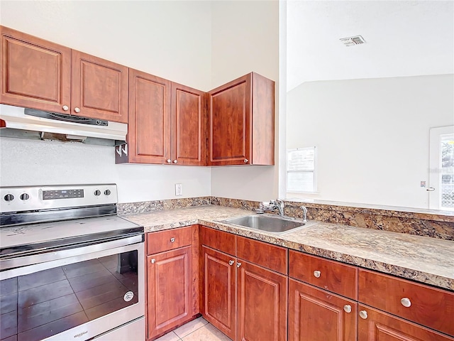 kitchen with sink, stainless steel electric range, vaulted ceiling, and light tile patterned flooring