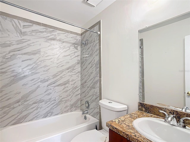 full bathroom with vanity, tiled shower / bath combo, and toilet