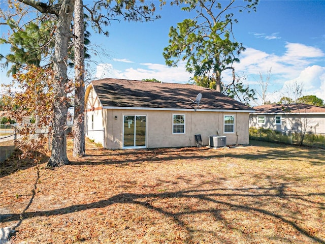 rear view of property with a yard and central AC