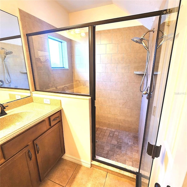 bathroom featuring tile patterned flooring, vanity, and a shower with shower door