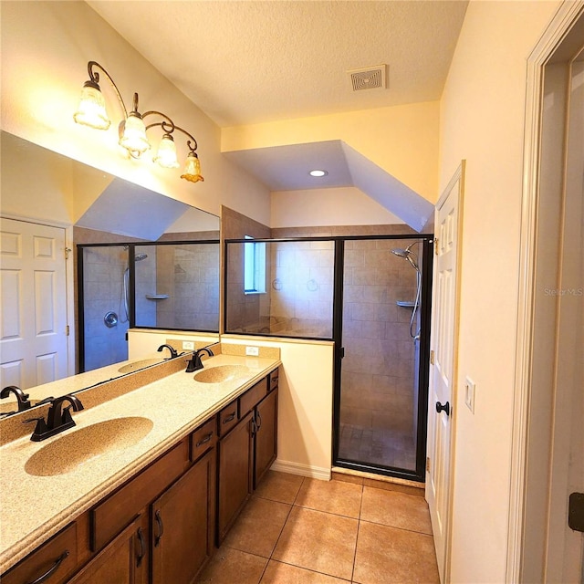 bathroom with tile patterned floors, vanity, an enclosed shower, and a textured ceiling