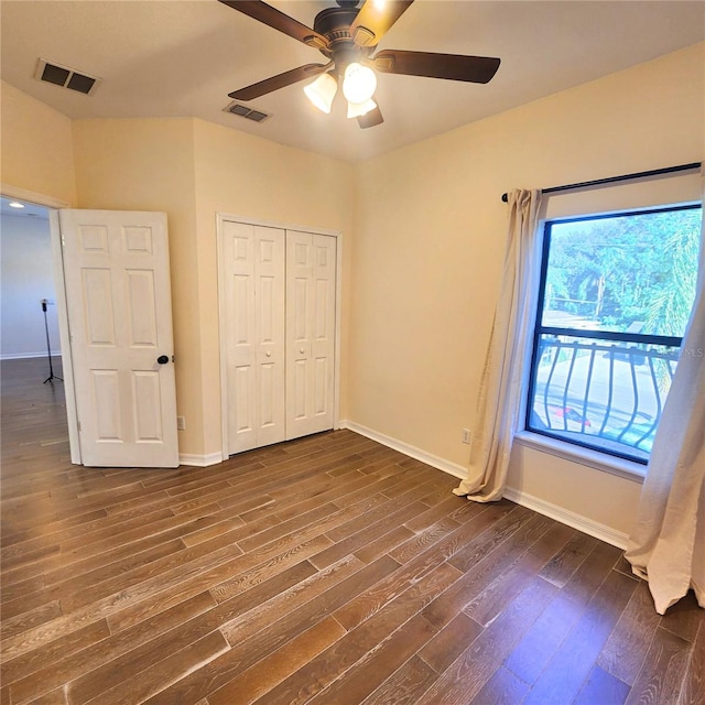 unfurnished bedroom featuring a closet, dark hardwood / wood-style floors, and ceiling fan