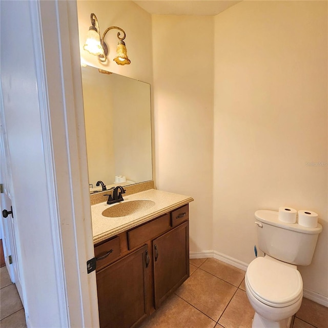 bathroom with toilet, vanity, and tile patterned floors