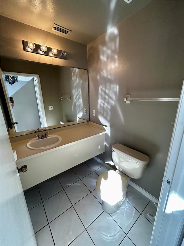 bathroom with tile patterned flooring, vanity, and toilet