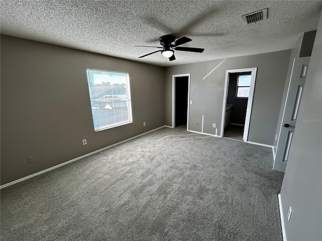 unfurnished bedroom with carpet, ensuite bathroom, ceiling fan, and a textured ceiling