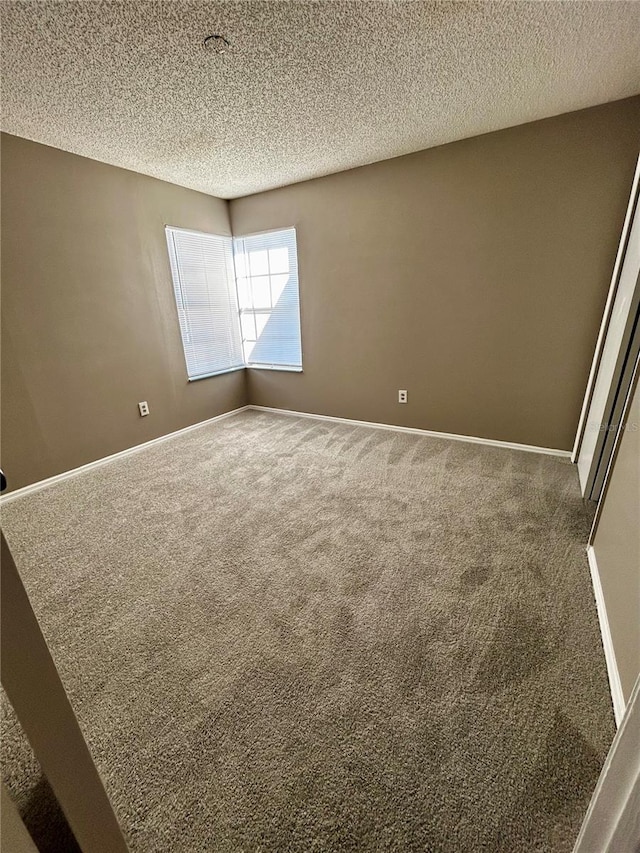 carpeted spare room featuring a textured ceiling