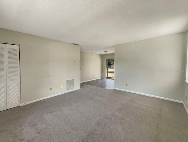 unfurnished room with carpet floors and a textured ceiling