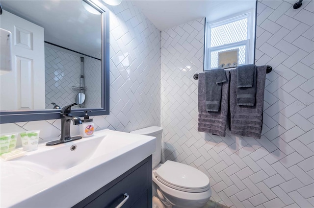 bathroom featuring vanity, toilet, and tile walls