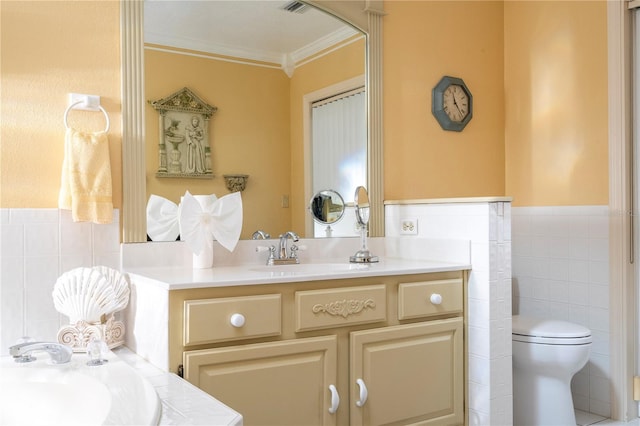 bathroom with vanity, toilet, tile walls, and crown molding