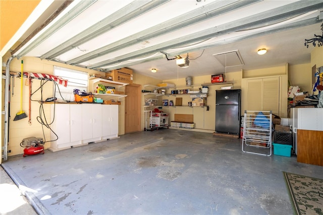 garage featuring black fridge and a garage door opener