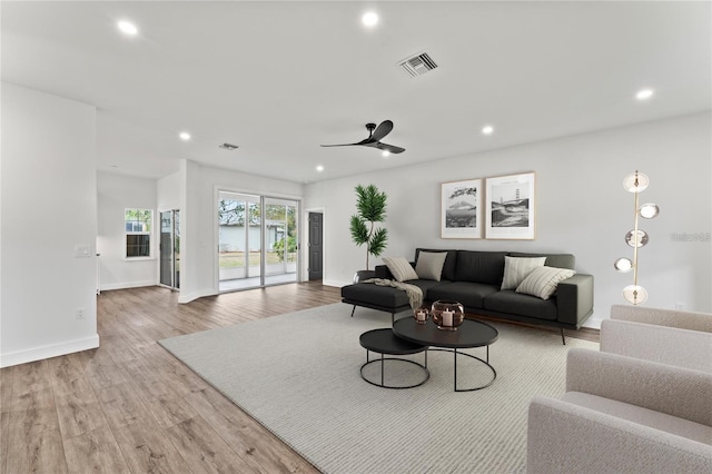 living room with light hardwood / wood-style flooring and ceiling fan