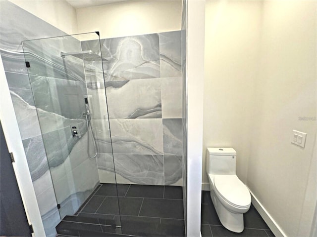 bathroom with tile patterned floors, toilet, and a tile shower