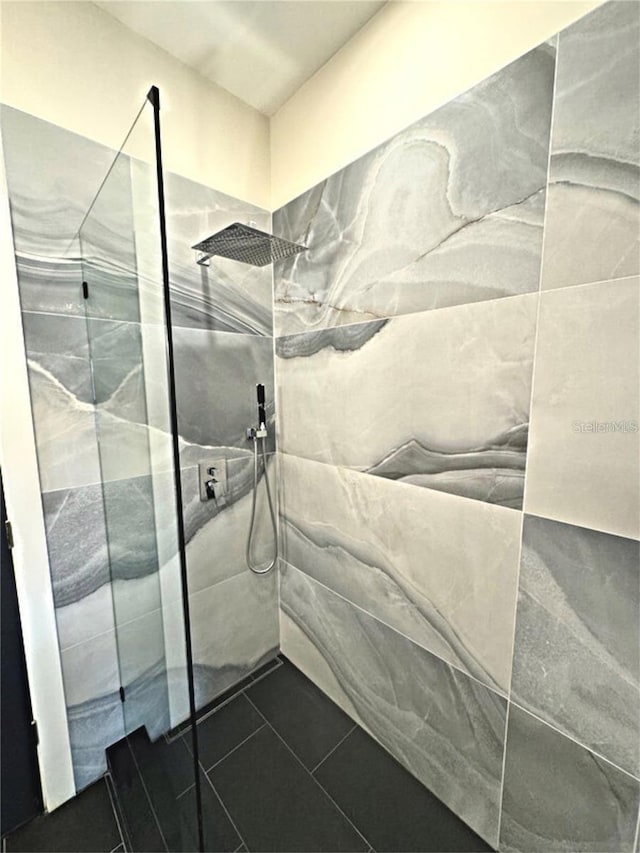 bathroom with tile patterned floors and tiled shower