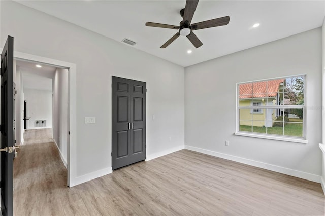 unfurnished bedroom with ceiling fan and light wood-type flooring