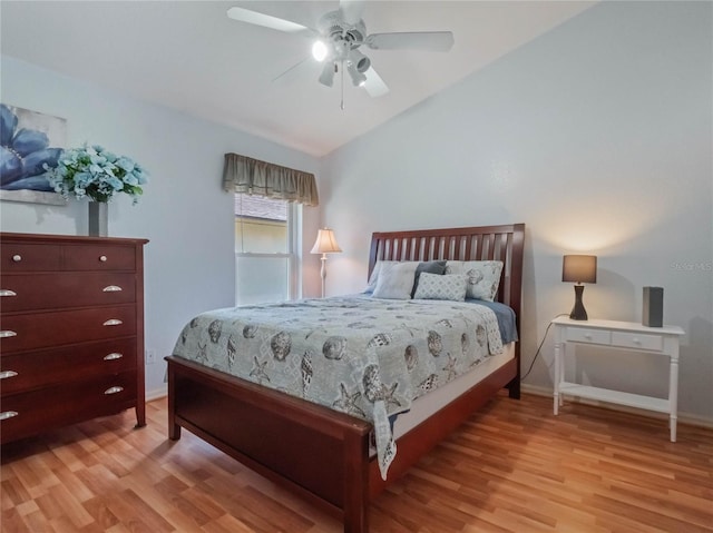 bedroom featuring light hardwood / wood-style floors, vaulted ceiling, and ceiling fan