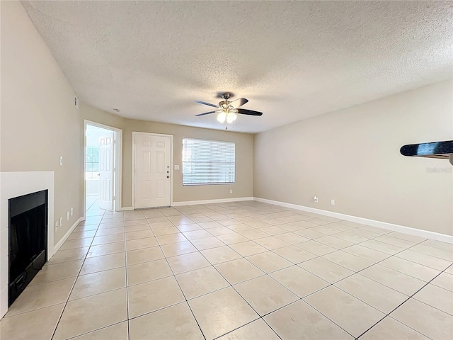 unfurnished living room with a textured ceiling, ceiling fan, and light tile patterned flooring