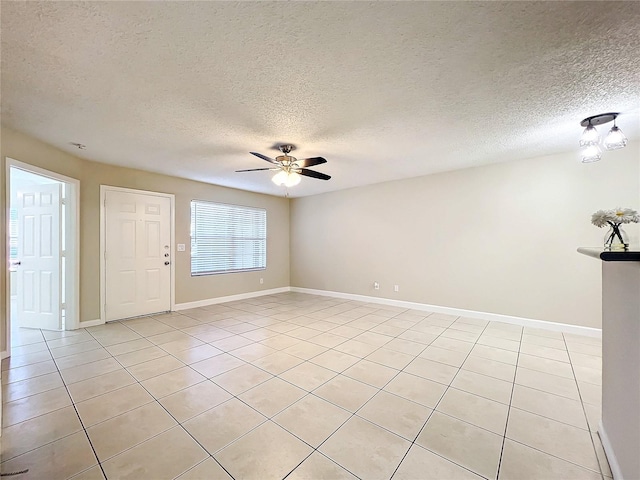 tiled empty room featuring ceiling fan and a textured ceiling