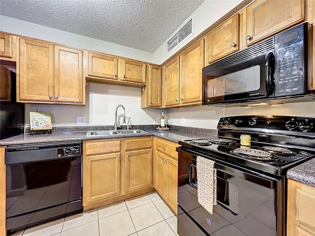 kitchen featuring sink, light tile patterned floors, black appliances, and a textured ceiling