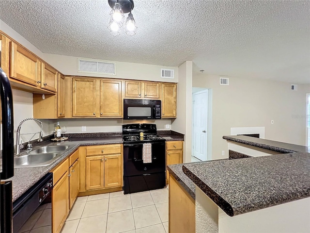 kitchen featuring a textured ceiling, sink, black appliances, a center island, and light tile patterned flooring