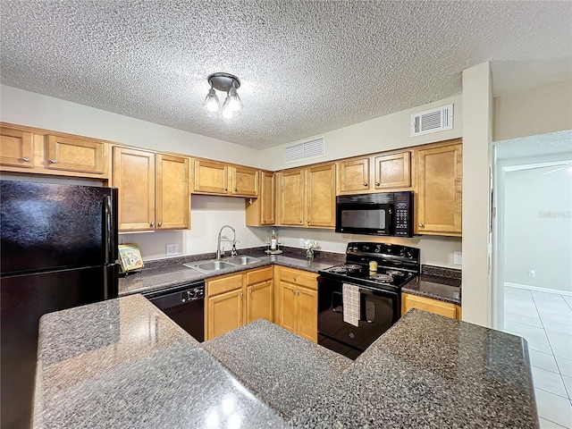 kitchen featuring black appliances, sink, dark stone countertops, light tile patterned floors, and a textured ceiling